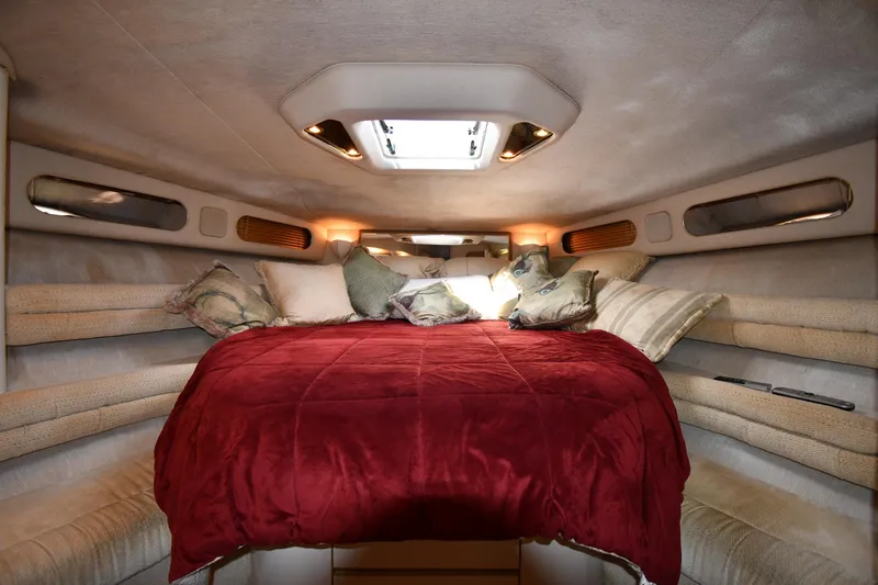  Yacht Photos Pics Luxurious cabin interior of 1995 Sea Ray 630 Sundancer with cozy bedding and ambient lighting.