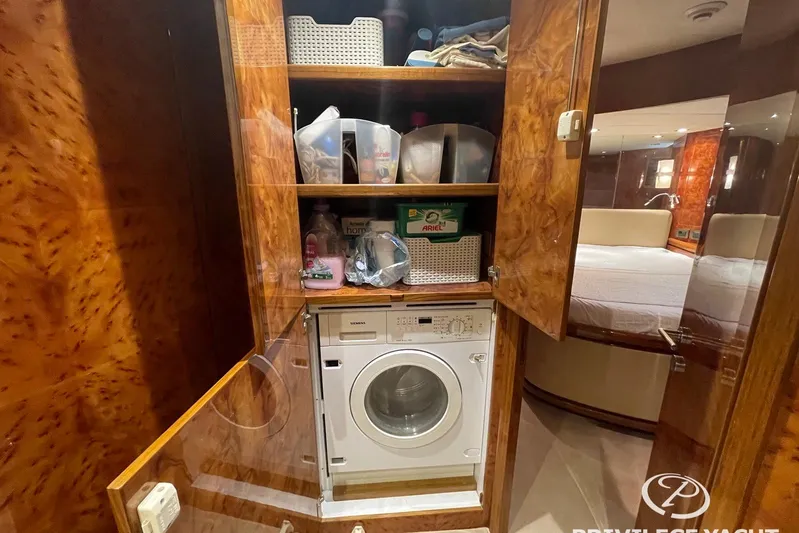  Yacht Photos Pics Laundry area on 2006 Monte Fino 76 yacht with washing machine and storage shelves.