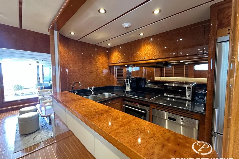  Yacht Photos Pics Luxurious kitchen interior of 2006 Monte Fino 76 yacht with modern appliances and wood finish.