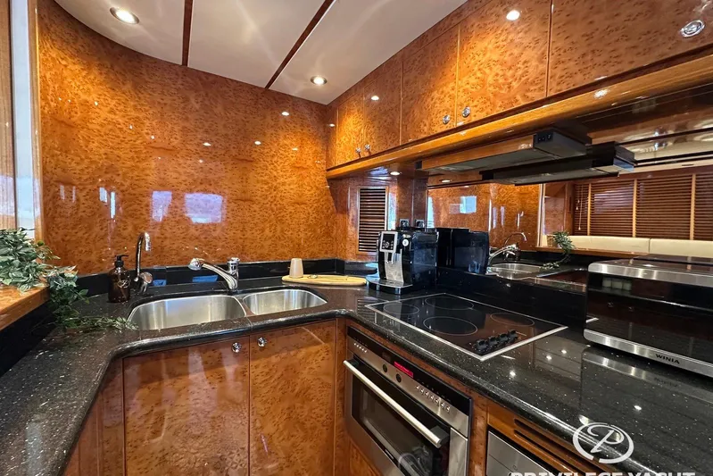  Yacht Photos Pics Luxurious kitchen interior of 2006 Monte Fino 76 yacht with modern appliances and wood finish.