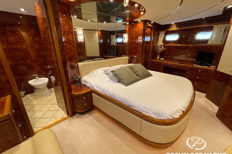  Yacht Photos Pics Luxurious bedroom interior of 2006 Monte Fino 76 yacht with elegant wood finishes.
