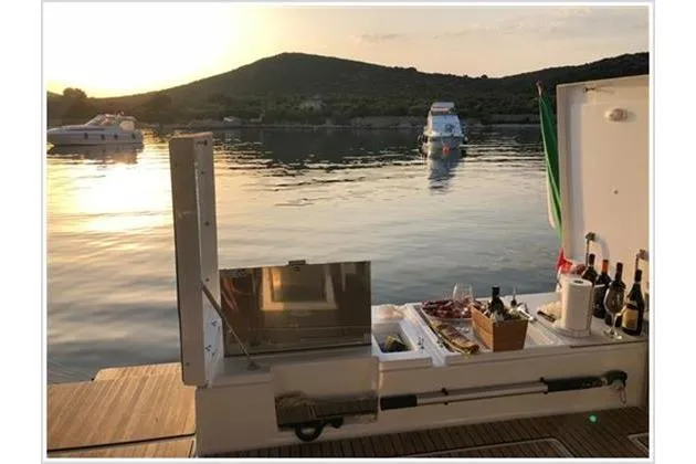  Yacht Photos Pics Luxurious 2017 Dufour Exclusive 56 yacht with outdoor dining setup at sunset.