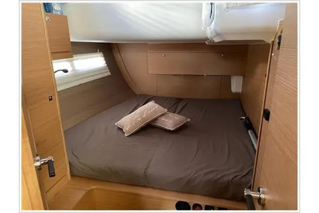  Yacht Photos Pics Cabin interior of 2017 Dufour Exclusive 56 yacht with cozy bed and wooden finish.