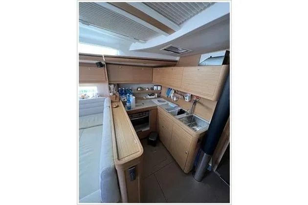  Yacht Photos Pics Modern kitchen interior of 2017 Dufour Exclusive 56 yacht, featuring sleek wooden cabinetry.