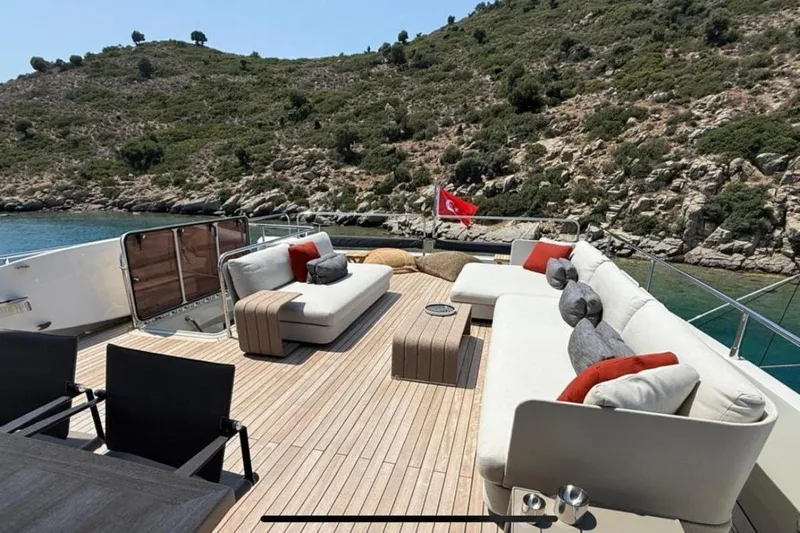  Yacht Photos Pics Luxurious 2022 Numarine 22XP yacht deck with elegant seating, scenic coastal backdrop.
