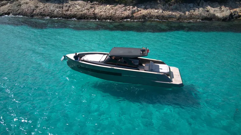 New 2025 Moon 45 Sports Line Yacht Photos Pics 2025 Moon 45 Sportsline yacht cruising in clear turquoise waters near rocky shoreline.