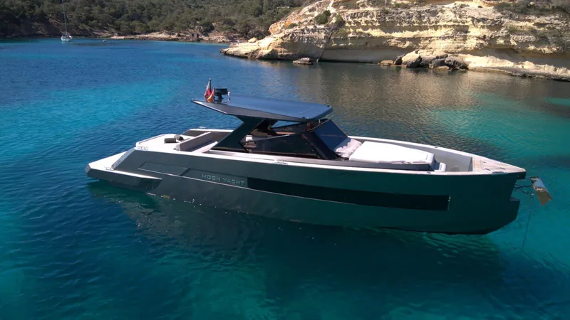 New 2025 Moon 45 Sports Line Yacht Photos Pics 2025 Moon 45 Sportsline yacht in clear blue water near rocky shoreline.