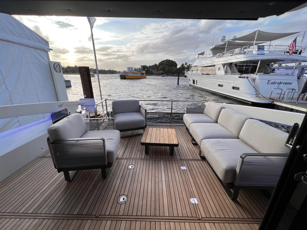 Luxurious deck of 2025 Absolute 48 Coupe yacht with elegant seating and scenic waterfront view.