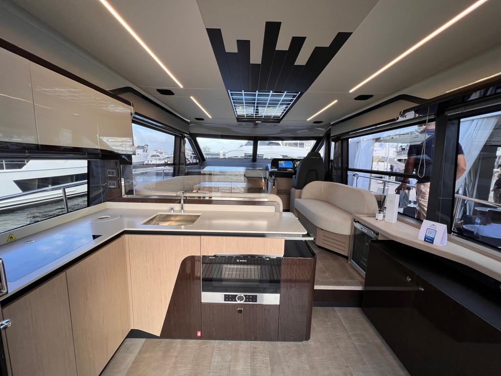 Luxurious interior of 2025 Absolute 48 Coupe yacht with modern kitchen and seating area.