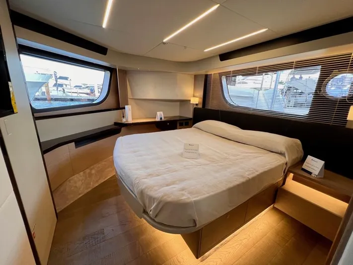  Yacht Photos Pics Luxurious bedroom interior of 2025 Absolute 48 Coupe yacht with modern design and large windows.