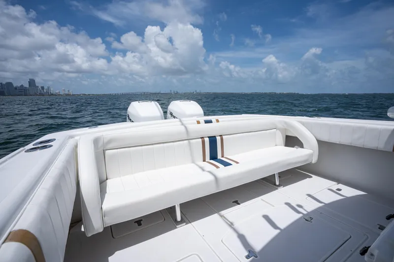  Yacht Photos Pics 1999 Intrepid 35 boat interior with white seating, ocean view, and city skyline in the background.