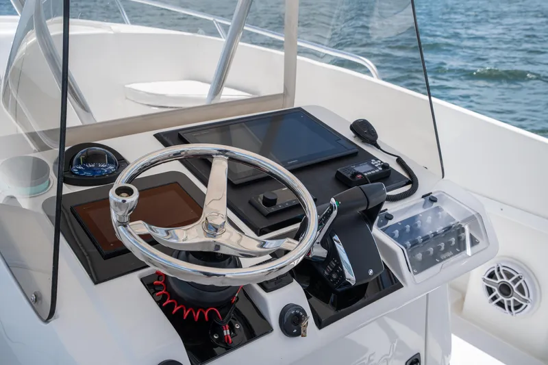  Yacht Photos Pics Control panel of a 1999 Intrepid 35 boat with steering wheel and navigation equipment.