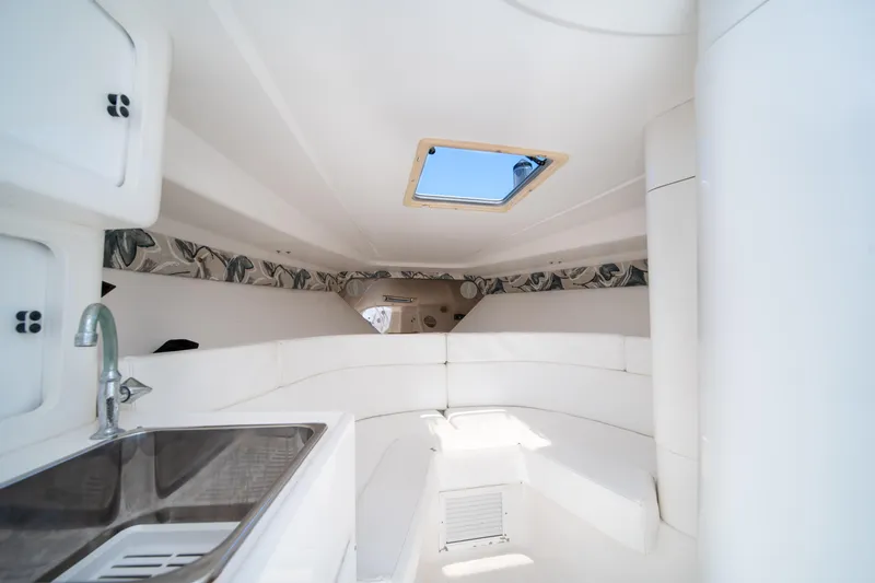  Yacht Photos Pics Interior of a 1999 Intrepid 35 boat with white seating and a skylight.