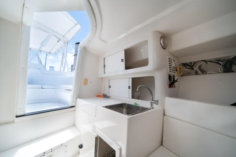  Yacht Photos Pics Interior of a 1999 Intrepid 35 boat featuring a compact kitchenette and seating area.