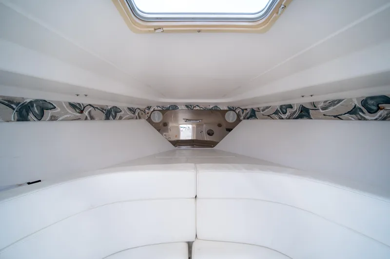  Yacht Photos Pics Interior cabin of a 1999 Intrepid 35 boat with white seating and patterned wall accents.