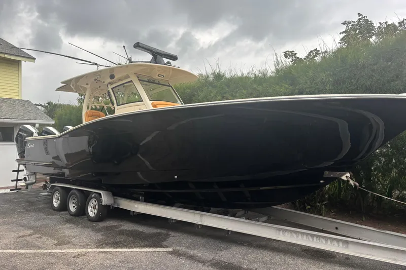  Yacht Photos Pics 2014 Scout 350 LXF boat on trailer, parked outdoors under cloudy sky.