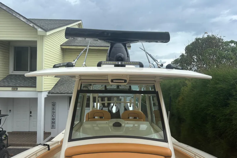  Yacht Photos Pics 2014 Scout 350 LXF boat with radar, docked near a house.