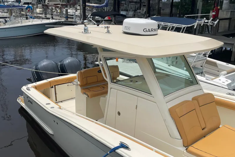  Yacht Photos Pics 2015 Scout 300 LXF boat docked, featuring dual engines and tan seating.