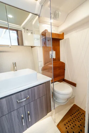  Yacht Photos Pics Luxurious bathroom in 2022 Regal 36 Grande Coupe yacht with modern fixtures and wood accents.