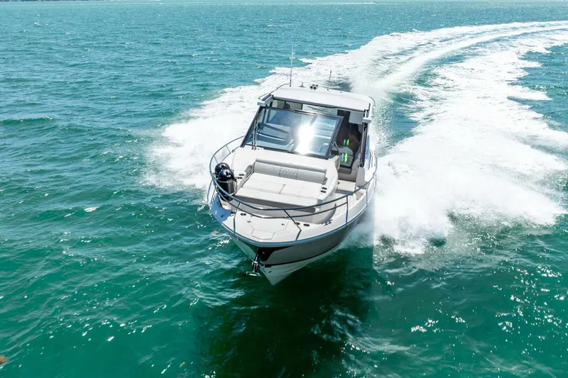  Yacht Photos Pics 2022 Regal 36 Grande Coupe cruising on open water, creating a dynamic wake.