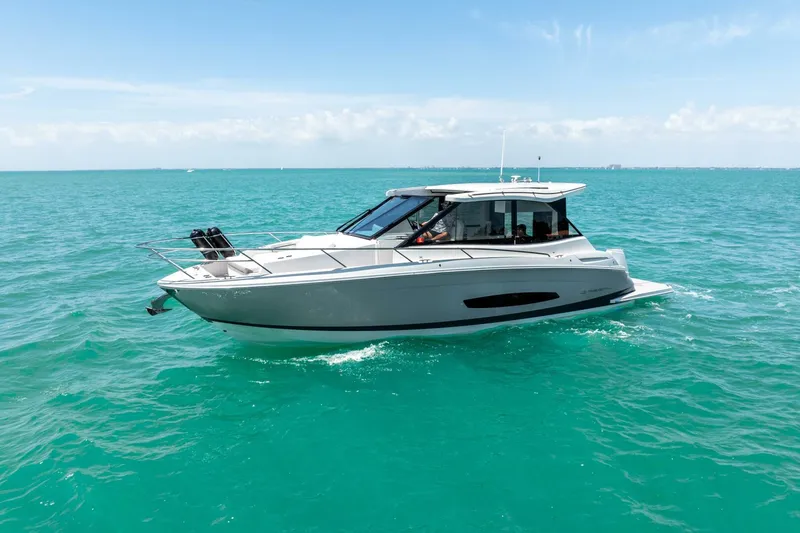  Yacht Photos Pics 2022 Regal 36 Grande Coupe cruising on turquoise ocean waters.