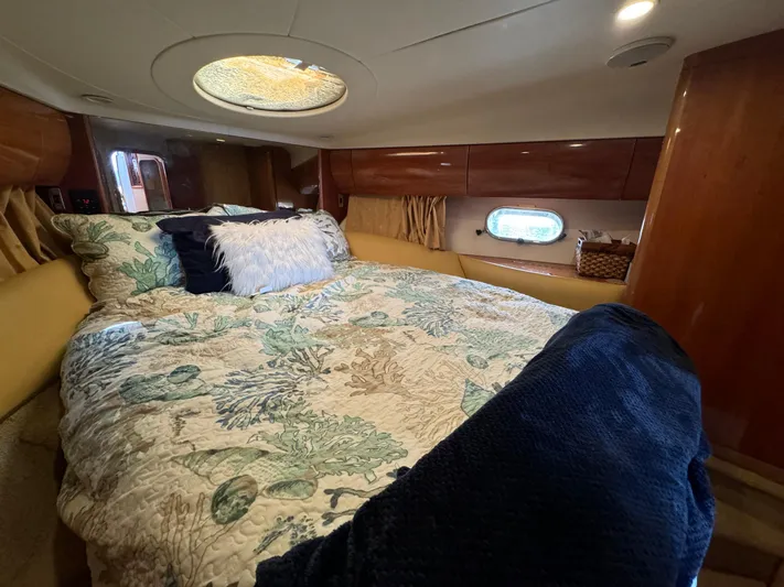 4 Aces Yacht Photos Pics Luxurious bedroom interior of 2001 Viking Princess 45 Flybridge yacht with skylight and cozy bedding.