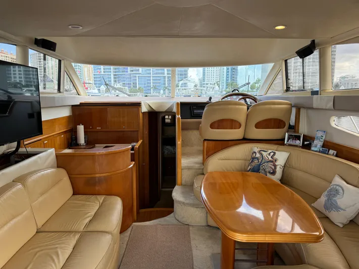 4 Aces Yacht Photos Pics Luxurious interior of a 2001 Viking Princess 45 Flybridge yacht with leather seating and wooden table.