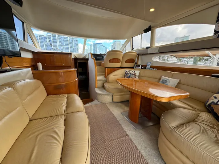 4 Aces Yacht Photos Pics Luxurious interior of a 2001 Viking Princess 45 Flybridge yacht with leather seating and wooden table.