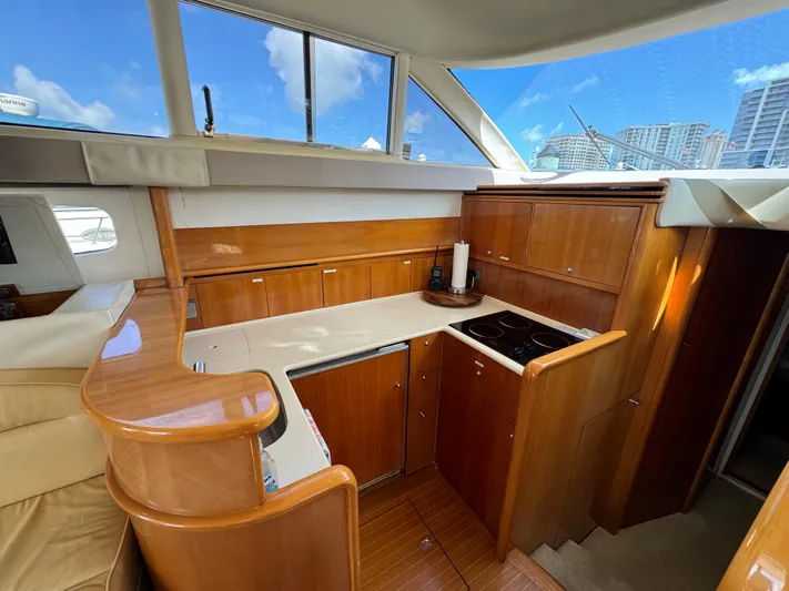 4 Aces Yacht Photos Pics 2001 Viking Princess 45 Flybridge yacht kitchen with wooden cabinetry and modern appliances.