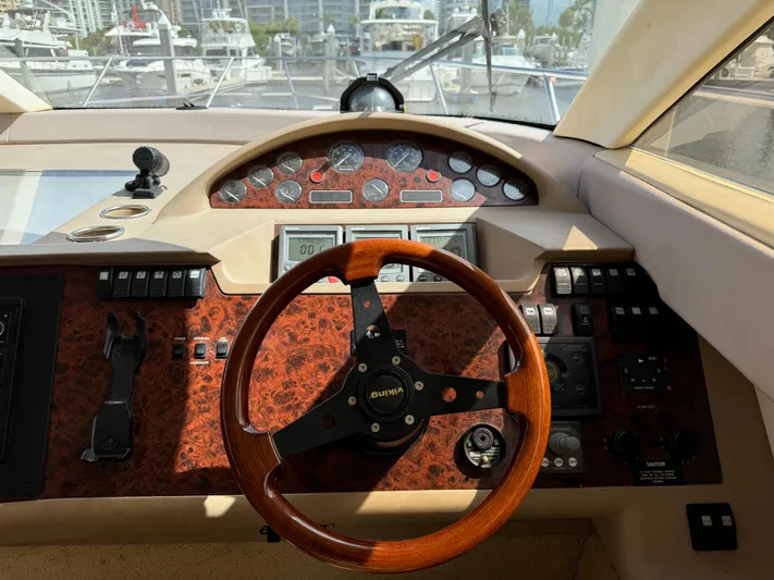 4 Aces Yacht Photos Pics Helm of 2001 Viking Princess 45 Flybridge yacht with wooden steering wheel and control panel.