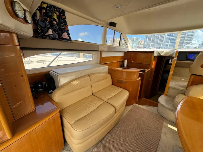 4 Aces Yacht Photos Pics Interior of 2001 Viking Princess 45 Flybridge yacht with beige leather seating and wooden cabinetry.