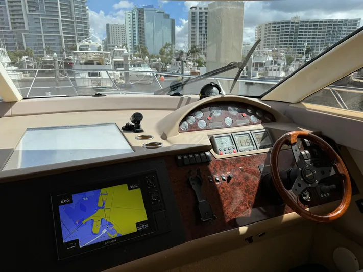 4 Aces Yacht Photos Pics 2001 Viking Princess 45 Flybridge yacht helm with navigation system and cityscape view.