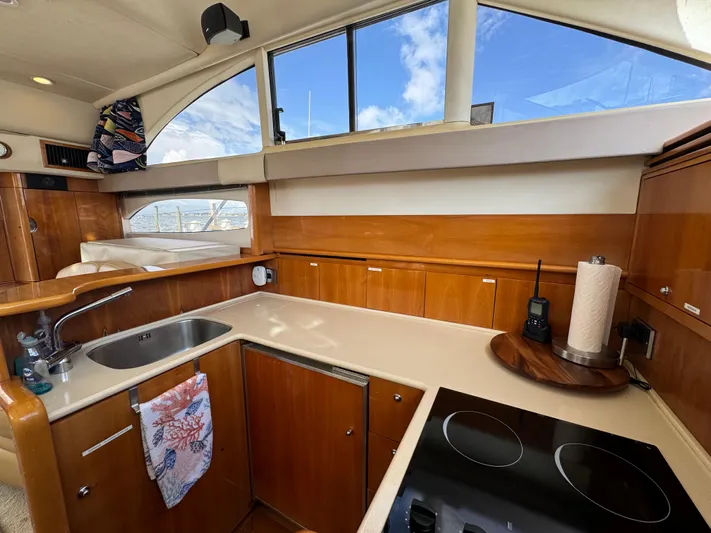 4 Aces Yacht Photos Pics 2001 Viking Princess 45 Flybridge yacht kitchen with wooden cabinetry and modern appliances.