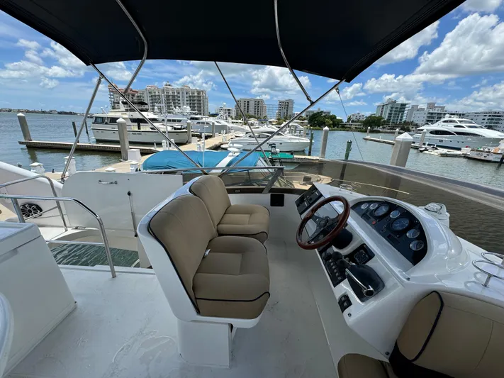 4 Aces Yacht Photos Pics Flybridge of 2001 Viking Princess 45 yacht docked at marina with cityscape background.