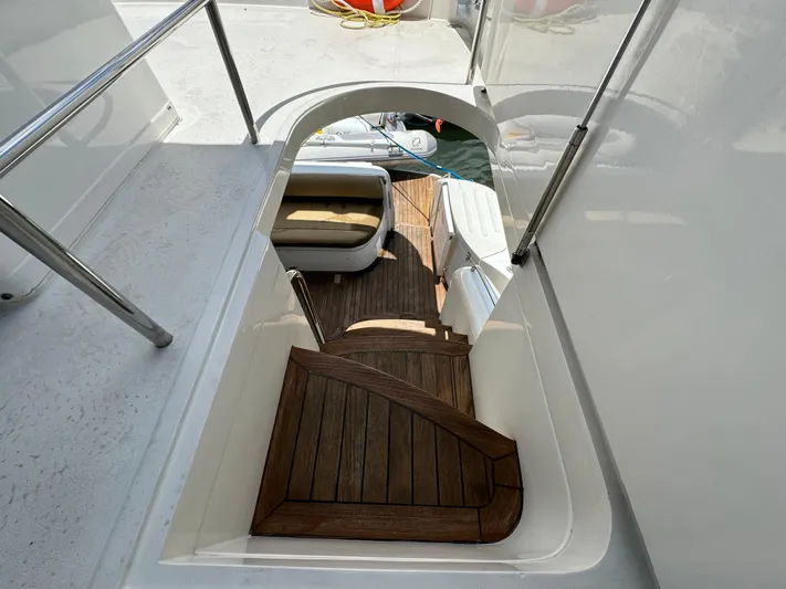 4 Aces Yacht Photos Pics 2001 Viking Princess 45 Flybridge yacht with wooden steps leading to lower deck.