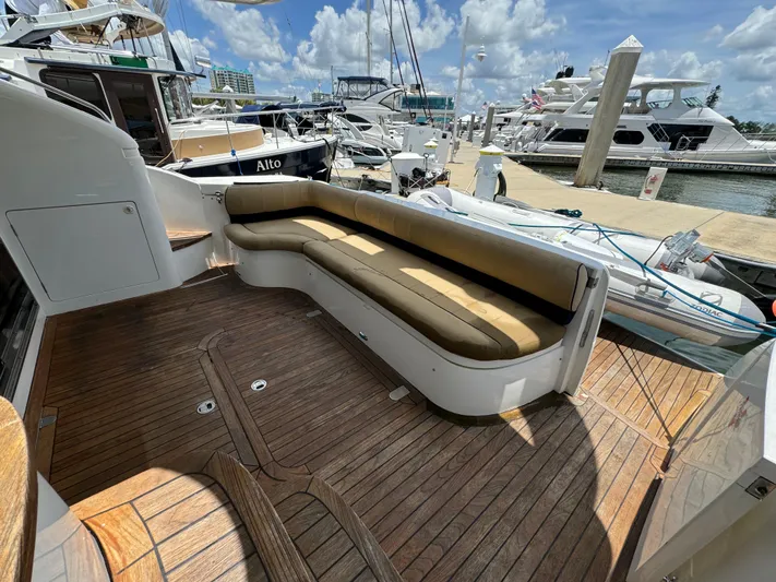4 Aces Yacht Photos Pics Viking Princess 45 Flybridge 2001 yacht with spacious teak deck and cushioned seating at marina.