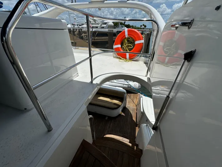 4 Aces Yacht Photos Pics 2001 Viking Princess 45 Flybridge yacht with wooden steps and lifebuoy on deck.