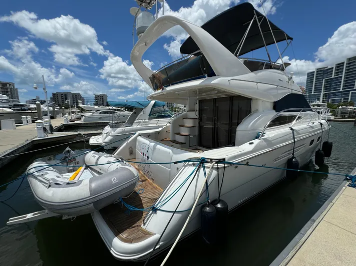 4 Aces Yacht Photos Pics 2001 Viking Princess 45 Flybridge yacht docked at a marina under a sunny sky.