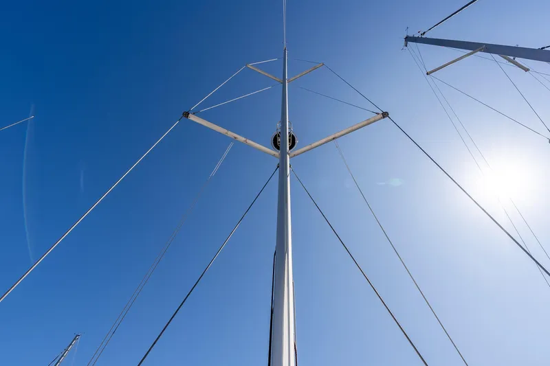 Victory Yacht Photos Pics Mast of 2018 Jeanneau Sun Odyssey 479 sailboat against clear blue sky.