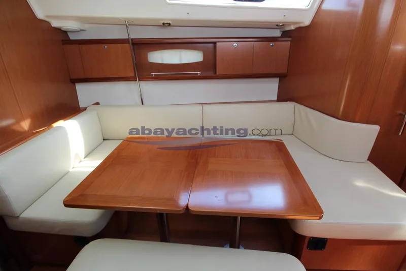  Yacht Photos Pics Interior of 2007 Beneteau Oceanis 43 yacht with wooden table and cream seating.