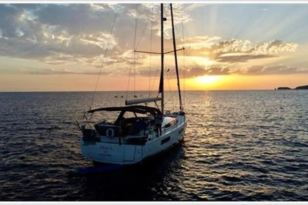  Yacht Photos Pics 2021 Jeanneau 60 sailboat at sunset on the ocean, serene and picturesque view.