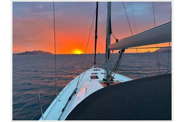  Yacht Photos Pics Jeanneau 60 sailboat at sunset, 2021 model, cruising on open water.