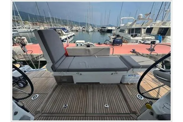  Yacht Photos Pics 2021 Jeanneau 60 yacht deck with seating, docked in a marina.