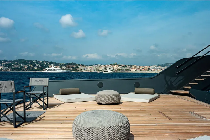  Yacht Photos Pics Luxurious deck of Maori 125 yacht, 2029 model, with scenic coastal view.