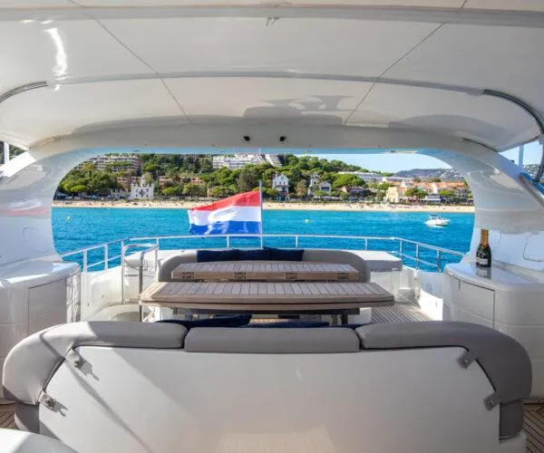  Yacht Photos Pics Luxurious 2009 Maiora 31DP yacht deck with seating, table, and scenic ocean view.