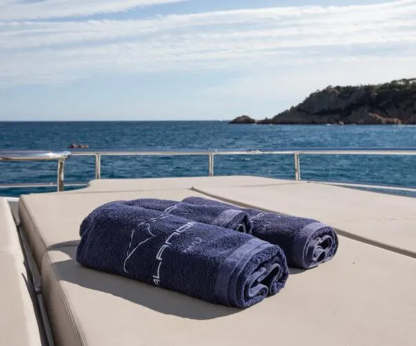  Yacht Photos Pics Luxurious Maiora 31DP yacht deck with towels, overlooking serene ocean and distant coastline.