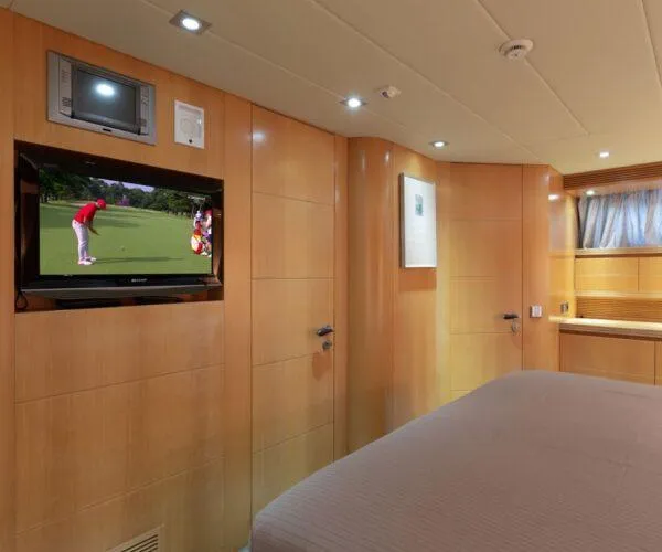  Yacht Photos Pics Luxurious Maiora 31DP 2009 yacht bedroom with TV, wood paneling, and modern decor.