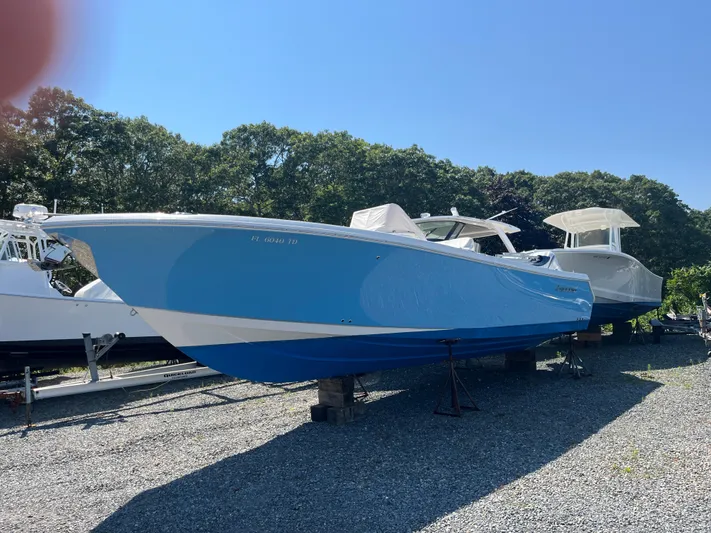  Yacht Photos Pics 2022 Sailfish 320 CC boat in blue, parked on gravel lot.
