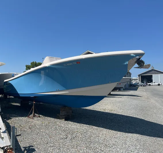  Yacht Photos Pics 2022 Sailfish 320 CC boat in dry dock, blue hull, sunny day.