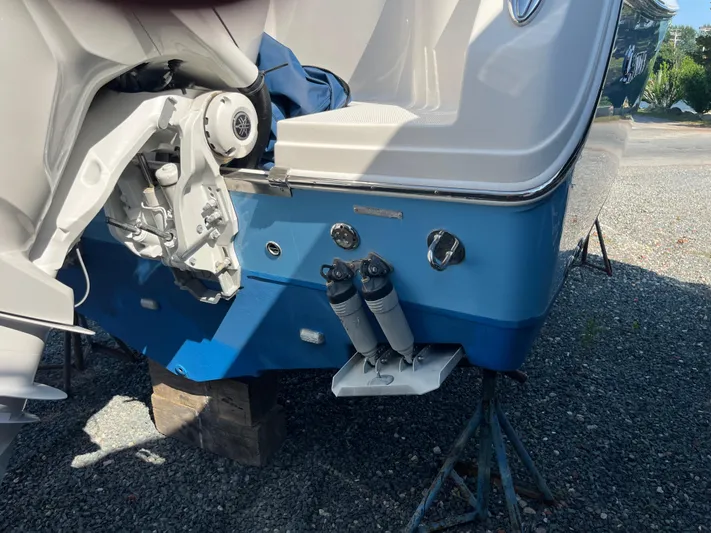  Yacht Photos Pics 2022 Sailfish 320 CC boat stern on a stand, showing engine mount and trim tabs.